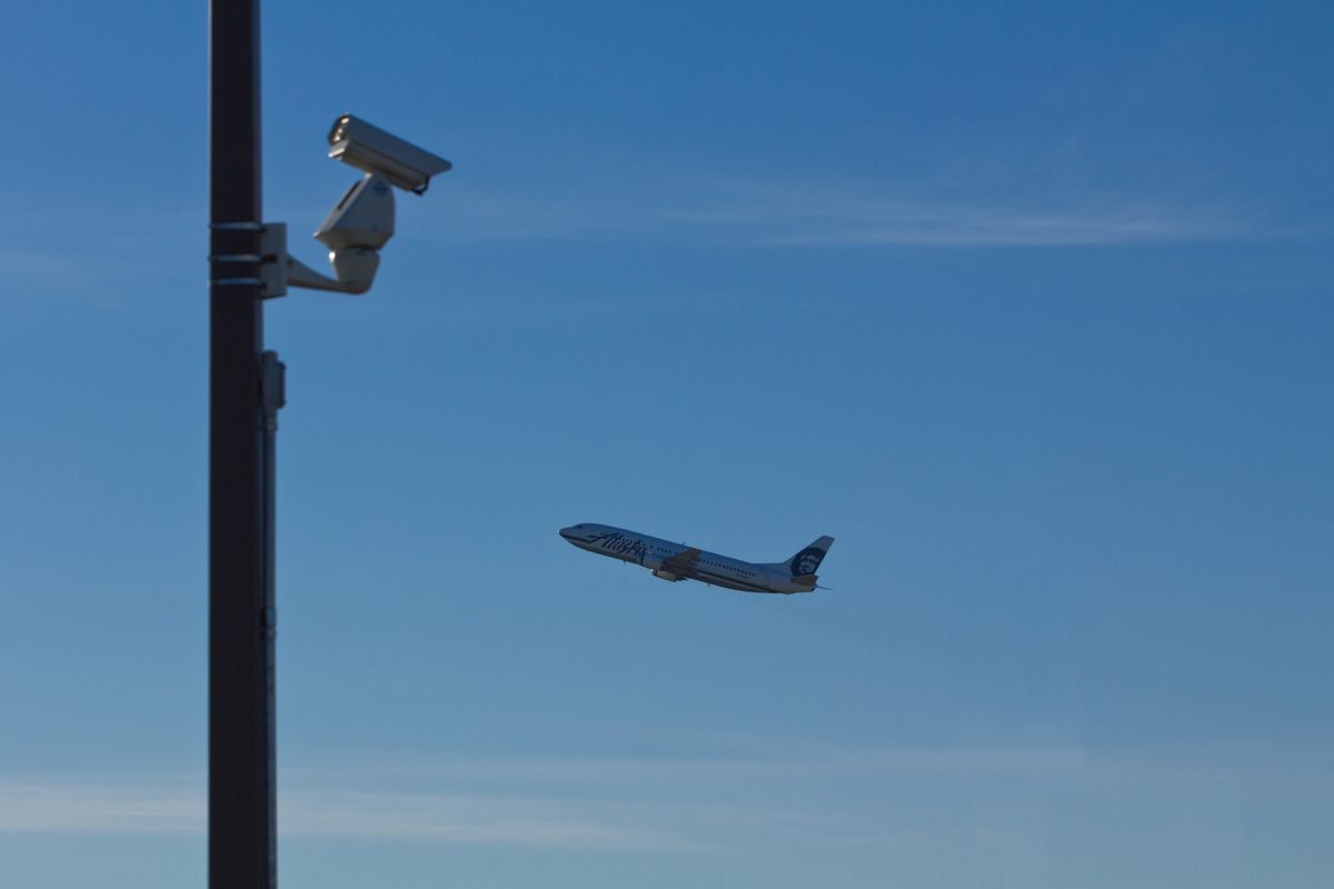 Photographers with telephoto lenses pointed at the sky, plane spotting near an airport