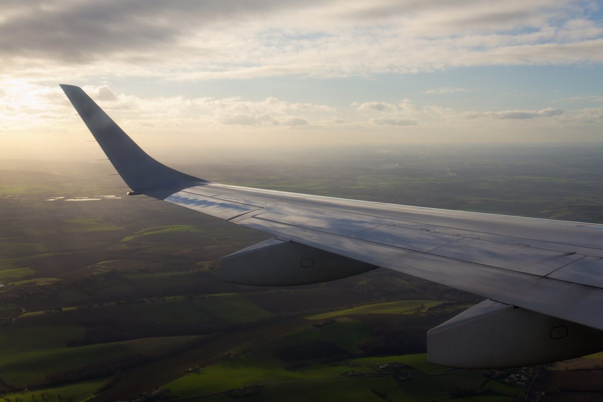Embraer 190 winglet viewed from inside the aircraft at sunset, showing the distinctive upturned wingtip shape